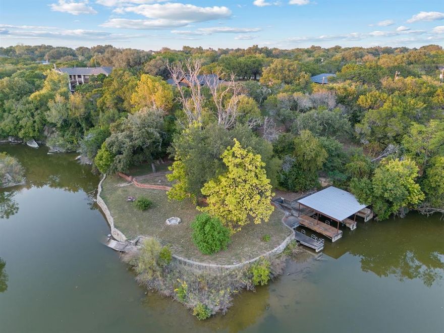 Welcome to your dream waterfront retreat on Lake Granbury! This stunning 3-bed, 2.5-bath home offers the perfect blend of modern upgrades, natural beauty, & peaceful privacy. Nestled on over an acre & surrounded by more than 65 mature cedar trees, the property has the feel of a secluded mountain lodge situated on the water’s edge. 

Inside, the home features 2 spacious living areas & a cozy wood-burning stove, ideal for quiet evenings in. Granite countertops run throughout the home with upgraded KitchenAid black stainless-steel appliances in 2023. Beautiful knotty pine stairs lead to the upper level, where you’ll find pine flooring & a private terrace—perfect for soaking in spectacular lake views. 

The exterior showcases a striking black modern finish with cedar accents, blending contemporary design with rustic charm. The massive covered deck extends across the entire back of the home overlooking low maintenance landscaping that feel like a private oasis. 

This waterfront haven features a double spiral staircase that leads down to a recreational paradise. Enjoy 3 concrete boat slips, 2 of which are covered, convenient kayak storage, & multiple spots to relax right by the lake. The fully heated, cooled, & insulated 16'x24' workshop, 2-car garage with upgraded modern doors, & additional covered parking offer plenty of room for all your lake toys. 

Recent updates include a Class 4 roof added in 2020, a 4.5-ton AC unit in 2022, a fully decked attic running the entire length of the house, & a 12-zone irrigation system can pull from the lake! Community residents enjoy access to tennis courts, pickleball courts, a picnic area, a pool, & a private boat ramp. Perfectly situated on a lake that never runs dry, this one-of-a-kind property is ideal as a full-time residence, weekend getaway, or high-performing investment with short-term rentals permitted. Schedule your private showing today & experience Lake Granbury living at its best!