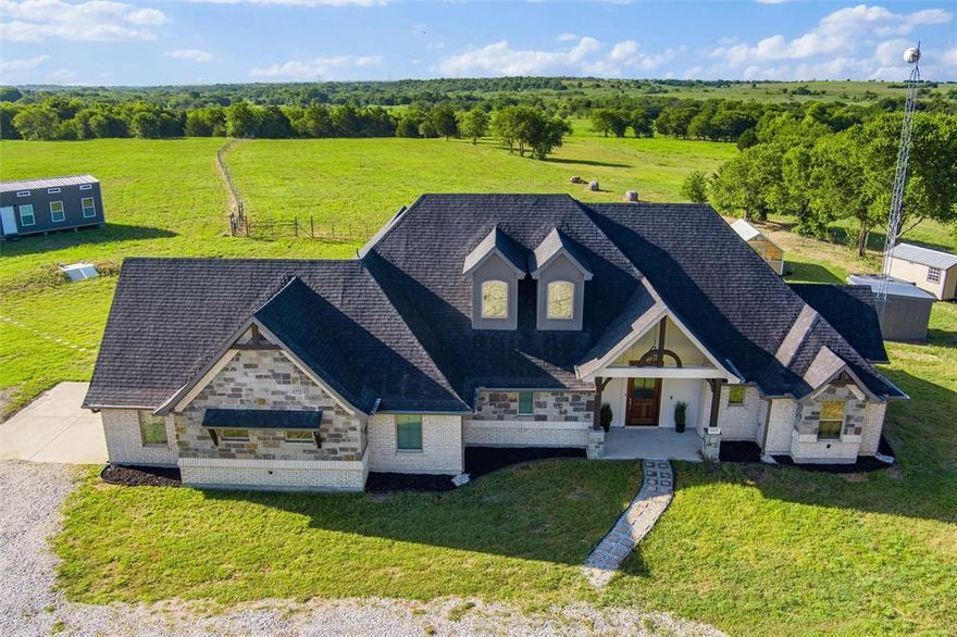 Modern Ranch Retreat on 13.23 Acres with Ag Exemption

Set on 13.23 acres of pristine, fully fenced land, this modern ranch estate delivers a rare blend of sophistication, privacy, and practicality—complete with an agricultural exemption for significant tax savings. Designed for both elegance and function, the home showcases seamless indoor-outdoor living framed by expansive views of rolling hills and serene water features.

The thoughtfully designed floor plan offers 3 bedrooms and 2 bathrooms, including a private primary suite with a spa-inspired bath, double vanity, oversized walk-in shower, and a custom closet connecting directly to the laundry room. A chef’s kitchen anchors the home with quartz countertops, floor-to-ceiling cabinetry, high-end appliances, a massive pantry, and a statement island for gathering. The open living and dining area is bathed in natural light, highlighted by a dramatic glass wall leading to the covered back porch.

Upstairs, a versatile second level awaits—ideal for a game room, theatre, in-law suite, or additional bedrooms—with private balcony access to sweeping country views. Modern amenities include foam insulation, a new roof (July 2025), smart-home technology, and energy-efficient systems for year-round comfort.

Outdoor living is equally impressive: two stocked ponds, an enclosed well, storage shed, and a climate-controlled two-car garage with workshop potential. A built-in tornado shelter adds peace of mind, while the absence of an HOA ensures complete freedom to enjoy the land your way—whether for recreation, livestock, or simply a private sanctuary.

This exceptional property is more than a home—it’s a lifestyle. A rare opportunity to enjoy luxury living with all the benefits of wide-open Texas land.