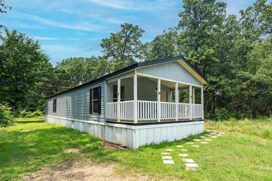 CLEAN & MOVE-IN READY! 2-2 singlewide surrounded by nice wooded areas on either side and across the street. Open concept kitchen-living-dining with covered front porch, great space for your morning coffee or evening wine. Property even includes the refrigerator, mini-dishwasher, and stackable washer & dryer! Good sized walk-in closets, excellent storage and cabinetry, well designed space. Close to dining, shopping, and medical with easy access for commute to Dallas or Tyler. CASH OR POSSIBLE OWNER FINANCING WITH 25% DOWN!