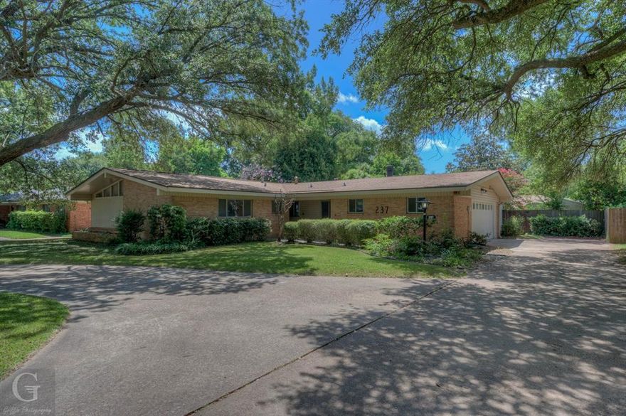 Welcome to your dream home where charm, comfort, and thoughtful updates come together seamlessly! This 3-bedroom, 2-bathroom, 2,279 square foot home is ready for its new owner! Step inside to find luxury vinyl plank flooring flowing throughout the home, leading you into a bright, spacious living room featuring a gas-starter, wood-burning fireplace framed by elegant built-in shelving. Just beyond, a gorgeous sunroom offers the perfect spot to relax, sip coffee, or unwind with a good book. The kitchen is a true standout with its stylish tile backsplash, updated cabinetry, and gas range, ideal for home chefs. A window over the sink provides a lovely view of the backyard oasis, letting in natural light and adding to the warm, inviting feel. The primary suite includes a private en suite bath with a stunning walk-in shower, offering both style and functionality. Step outside and you’ll fall in love with the serene backyard complete with a cozy patio shaded by mature crêpe myrtles and two convenient storage sheds. This home is the perfect blend of comfort, beauty, and practicality ready to welcome you home!