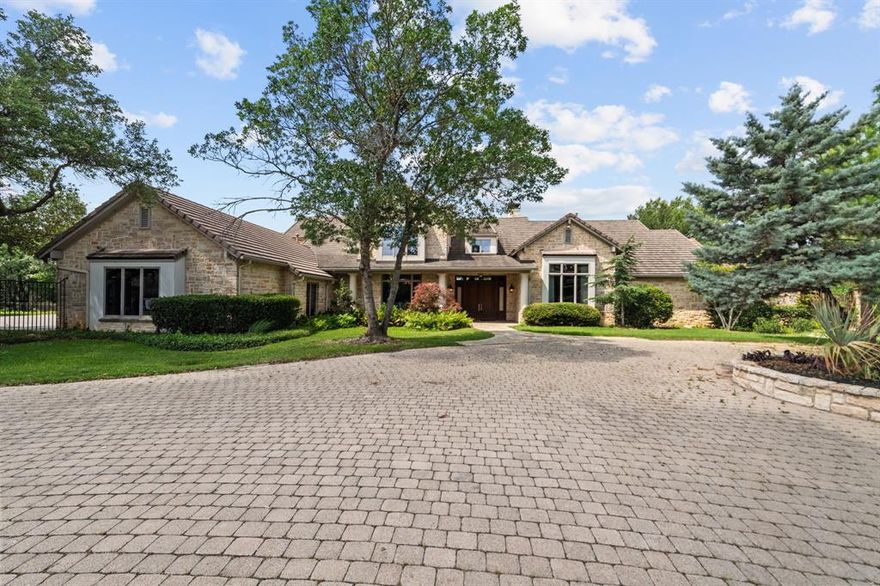 Welcome to an extraordinary hilltop estate nestled on over 2 acres in the prestigious and gated Estates on Rush Creek. Designed to impress while offering complete comfort, this home is perfectly positioned to capture breathtaking panoramic views and deliver a lifestyle of privacy, luxury, and ease. At the heart of the home is a chef’s kitchen outfitted with high-end appliances, generous prep space, and seamless flow into both casual and formal dining areas—ideal for hosting or everyday living. A spacious living area anchors the main level, highlighted by soaring ceilings with exposed wood beams and a dramatic stacked stone fireplace that brings warmth and character. The primary suite is a true retreat, offering an oversized bedroom, boutique-style closets, and a spa-like bath featuring heated floors, a built-in coffee bar, and direct access to a private patio. Just off the bath, a secluded courtyard with an outdoor rain shower enhances the resort-style experience. Two separate offices provide an ideal work-from-home setup with privacy and peace. Downstairs, a finished walk-out basement includes a full kitchen, bedroom, and full bath. With two additional bedrooms and two full and two half baths throughout the home, there’s space and comfort for everyone. Step outside and you'll discover an entertainer’s paradise: lush landscaping surrounds a sparkling pool and spa, alongside a cabana complete with a half bath. Whether relaxing in the sun, hosting guests, or enjoying a quiet evening, the backyard offers a sense of retreat that feels more like a private resort than a residence. Additional features an elevator, tornado shelter, and a stone wall encircling the property elevate both convenience and security, making this estate as functional as it is beautiful. This is luxury living at its finest, blending elegance, comfort, and a prime location into one unforgettable property.