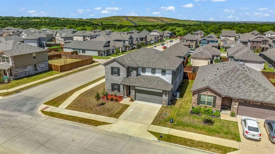 This Kessler by Meritage Homes on a corner lot is a spacious 2-story residence offering 3,000+ sq. ft. of beautifully designed living space with 5 bedrooms, 3 baths, and a versatile upstairs game room. From the moment you step inside, you’ll notice the open-concept layout seamlessly connecting the kitchen, dining, and living areas—perfect for both daily living and entertaining. The chef-inspired kitchen features a large island ideal for casual meals, homework, or gathering with friends during holidays. Natural light fills the home through energy-efficient windows, and smart-home tech makes controlling climate and security effortless. The downstairs primary suite offers a private retreat with dual sinks and a generous walk-in closet, while a secondary bedroom or home office is also on the first floor. Upstairs, the game room is a hub for fun—whether a movie night or lively game tournament—while 3 additional bedrooms provide space for family, guests, or hobbies. It’s easy to picture life here—mornings with sunlight streaming into the kitchen, weekends filled with laughter in the game room, and holidays where the open living space brings everyone closer. Beyond the walls, the neighborhood invites you outdoors with thoughtfully designed amenities including scenic walking trails, a vibrant playground, and a dedicated dog park—perfect for morning strolls, weekend playdates, or letting your pup run free. Whether you're enjoying nature, connecting with neighbors, or simply unwinding after a long day, these community features add another layer of comfort and charm to everyday living. Conveniently located near Uplift Elevate Preparatory, Lockheed Martin, downtown Fort Worth, and DFW Airport, this home offers a peaceful neighborhood feel with quick access to work, school, shopping, and entertainment.