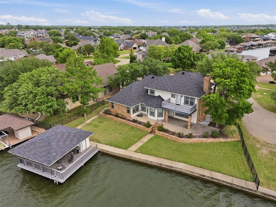 Waterfront dream on Lake Granbury’s Waters Edge. This lovely 3 bedroom, 3 bath, 2-car garage waterfront retreat sits on open water with 110 feet of shoreline, welcoming you with an impressive front facade and an iron decorative entry door. Waters Edge, a quiet waterfront subdivision, the home offers sweeping views of the main body of the lake and a lifestyle built for tranquil lake living.  Key features include a concrete seawall, a covered party dock with composite decking, sprinkler system, large trees, and a landscaped lawn. A large covered back patio invites outdoor living and morning coffee, while a private deck off the upper-level bedroom is perfect for sunshine therapy and lake vistas. Interior highlights include abundant windows framing the lake from every angle, a large living area with a fireplace, and a mix of wood, marble, and tile flooring. The updated kitchen showcases light quartzite counters and flows into a second living area or formal dining space off the kitchen. The primary suite is on the first level with a generous walk-in closet. Upstairs, the secondary bedrooms share a Jack-and-Jill bath. A coffee bar with a built-in fridge center on the bedroom level add convenience. Experience lake life at its finest in this peaceful lakeside retreat.