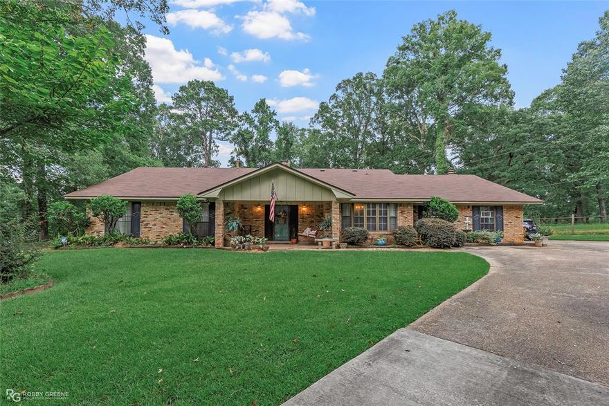 WELL MAINTAINED CUL-DE-SAC HOME WITH 2.23 ACRES OF LAND! Rare find in the back of Haughton's beloved Dogwood Subdivision, 3423 Gary Rex Circle sits atop a hill and has been owned and loved on by the same owner for 34 years. This ONE FLOOR, 3063 square foot home offers 4 bedrooms, 4 bathrooms, 2 living rooms, a sunroom, and a 2-car garage. Enjoy living near all city conveniences with easy proximity to Bellevue Road, Highway 80, and I-20, all while feeling like you're nestled away in a country setting far from the hustle and bustle and outside of the city limits. This 1979 built home has been well maintained and provides plenty of space and a flowing lay out for entertaining or gatherings. The charming curb appeal and cute front porch with a swing welcome you to step inside to the living room with vaulted ceilings and a cozy fireplace. Dine with company and friends in the formal dining room with bay windows overlooking the beautiful hill like landscape of the front. The kitchen has an abundance of cabinet space, granite countertops, a gas cooktop, room for barstools, and more space for entertaining opening into a spacious den area with another fireplace and built-ins for storage and seating. Laundry room is off the kitchen and has a full bath in it and access to the back patio. The sunroom is the perfect place to relax and overlook the pergola, patio, and the lush landscaping of the backyard. The primary suite has 2 en-suite baths allowing privacy and plenty of room for each to get ready without disturbing the other. The front left hallway has three bedrooms with a shared bath off the hallway. This well-built and thoughtfully designed home flows beautifully and provides storage at each turn. See photo for reference, but majority of the property is in the front of the home and to the right of the home as the lot next door is owned by the seller and is all one parcel. Come tour this lovely home today!