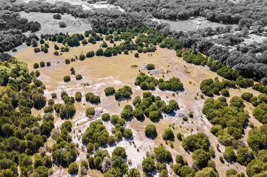 Situated in the Hill Country of Dallas, this 45-acre tract offers a prime residential development opportunity in Cedar Hill. Most of the land is zoned SF-22, with a smaller portion zoned RR, allowing flexibility for premium single-family development. Directly adjacent to a large planned city park, the property provides built-in lifestyle amenities that will enhance any future community. The property offers 1,600+ feet of frontage on S. Clark & 375+ feet on Stoney Creek, with 2 gated entry points for controlled access. A main water line is installed at the S. Clark entrance, & the City installed gas & high-speed internet infrastructure along S. Clark Road several years ago. A 15-inch VCP sewer line also traverses the property, providing critical utility access to support development. The northeast corner sits at one of the highest elevations in the region, delivering panoramic views of the surrounding Hill Country. A natural creek, pecan & peach trees, & seasonal bluebonnets add organic character & visual appeal. The property lies along the Balcones Escarpment, Cedar Hill’s most defining physical feature, which rises above 880 feet mean sea level. Recognized as the highest point between the Red River & the Gulf Coast, this unique topography creates opportunities for premium residential lots & distinctive community design. The site is strategically located across from horse stables & a public park with walking trails, adjacent to Plummer Elementary, & near the Cedar Hill Fire Station. Permitted by-right uses include a private country club, golf course, church, & non-commercial radio tower, but the property is ideally suited for a master-planned community or luxury residential development. With its combination of size, location, topography, established utilities, & proximity to civic & recreational amenities, this tract represents one of the few remaining large-scale residential development opportunities in Cedar Hill & offers significant long-term investment upside.