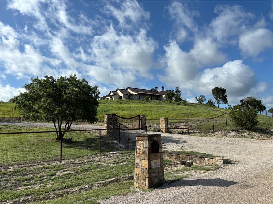 Situated on one of the premium lots in the highly sought after Silverado on the Brazos community, 701 Cactus Rio Drive is located on a high, picturesque bluff; its elevated position offers unobstructed 360 degree views, beautiful sunrises and outstanding sunsets.  This unique property boasts spacious interiors covering 2930 sq. ft., 3-2.5-3, upper level media room and 1091 sq. ft. of covered porches.  The light-filled open floor plan includes main, kitchen and dining areas, with an office-library off the entrance. French doors open to the pool deck from the main room and all three bedrooms. The primary suite includes granite countertops, his and hers custom sinks, jacuzzi tub, multi-head shower and large walk-in closet.  Two guest rooms, Jack and Jill bath with gorgeous granite and custom sinks, a generous pantry, separate granite countered bar, spacious mudroom and stairs to the media room complete the efficient layout.  A Claffey custom pool-spa extends from the sizable deck overlooking tree covered vistas, with the Brazos River just a minute away.  Special custom details include high-end appliances, custom alder wood cabinetry and 8 foot doors, Murano glass chandelier and fixtures, beautiful, reclaimed wood floor, high-end standing seam metal roof, incredible panoramic views from every window and more.  
   This equine ready, 6.55 AG exempt acreage is perimeter fenced, encompasses three separate pastures and a stone-faced 1800 sq. ft. barn with two oversized stalls, tack room and wash rack.  Included are a 2024 Polaris Ranger, a 2015 Hustler X-ONE, a 2010 Ford F-150, many tools and numerous furnishings.  
   Enjoy the serenity of the immediate quiet, the beauty of the rolling hills, and the small, exclusive community of prized real estate.  Seeing is believing!