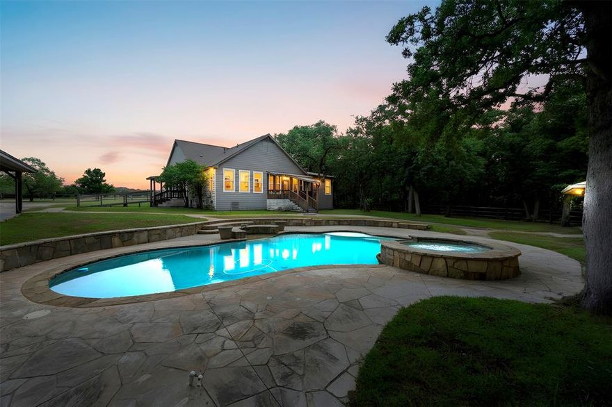 Exceptional 12.5-Acre Private Estate: The Ultimate Rural Retreat only minutes from Lake Granbury. Discover unparalleled serenity with this  picturesque retreat, perfectly positioned amidst a lush canopy of mature oak and mesquite trees. Accessed via two private gated entrances, this meticulously maintained property is fully cross-fenced, offering an ideal setup for livestock, horses, or a private homestead. Upon entry, you are greeted by stunning open meadows that transition seamlessly into a heavily wooded and tranquil landscape, providing a rare sense of seclusion and natural beauty. At the heart of the estate is a sophisticated 4-bedroom, 3-bathroom Craftsman-style home. The residence exudes curb appeal with an expansive, welcoming front porch designed for quiet mornings and breathtaking sunset views. The interior craftsmanship is matched by an extraordinary outdoor oasis featuring a sparkling in-ground pool and integrated hot tub, creating a resort-like atmosphere for relaxation and leisure. Enhancing the property’s versatility is a 1,000-square-foot studio-style pool house. This fully self-contained living space features a full kitchen, a modern bathroom, and a spacious walk-in closet. Whether utilized as a guest or mother-in-law suite, an office, or outdoor entertaining, this space offers endless possibilities. For the hobbyist or professional, the property includes a massive barn-shop, providing ample room for equipment, projects, or storage. Additionally, a dedicated parking pad for an RV or boat comes complete with full hookups, ensuring your recreational vehicles are always adventure-ready. Whether you are seeking a peaceful permanent residence, a working ranch for cattle and horses, or a sophisticated Weekend getawayretreat? This rural escape offers unlimited potential. Towering trees, lush pastures, and comprehensive amenities, this property is a rare find in today’s market. Schedule your private tour today to experience this one-of-a-kind sanctuary.
