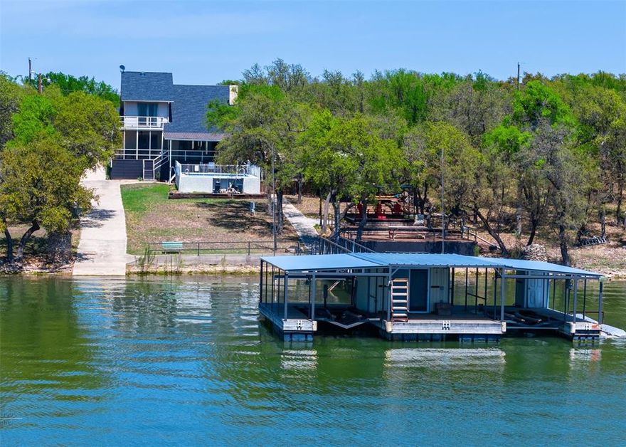 Enjoy lake living with income potential in this well-maintained 3-bedroom with additional Bonus bunk room, 3-bath waterfront home on Brownwood Lake. Currently operating as a successful Airbnb, the property is sold fully furnished and move-in ready, offering flexibility for personal use or continued short-term rental performance. The layout includes two generous living areas, a functional loft, and a balcony with lake views, creating space for both everyday comfort and entertaining. Built with durability in mind, the home features 2x6 stud walls for added insulation and a solid feel throughout, along with a 2-car garage for parking and storage. Outdoor spaces are designed for relaxation and recreation, featuring a swimming pool with pool house, patio area, and multiple covered porches ideal for enjoying the water setting. The private boat dock includes two boat lifts, built-in storage, and two floating ramps suitable for personal watercraft. A private boat ramp offers direct and convenient lake access. Whether used as a full-time residence, weekend getaway, or income-producing investment, this property offers a rare combination of lake frontage, amenities, and turnkey readiness—just in time for summer enjoyment. Schedule a private showing to experience Brownwood Lake living firsthand.