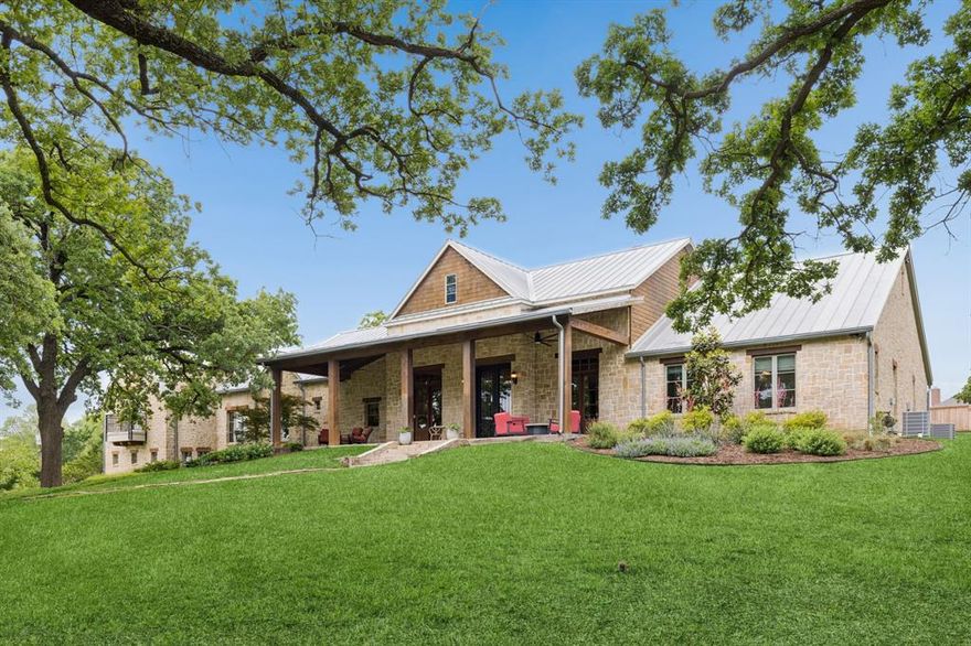 Set on scenic acreage in the heart of Argyle, this stunning farmhouse-style residence offers the perfect blend of rustic charm and expansive modern living. Designed with entertaining in mind, the open-concept layout seamlessly connects a grand living area to the kitchen and dining spaces, creating an inviting atmosphere that feels both spacious and warm. Every inch of this exceptional home delivers versatility and comfort—from the oversized bedrooms to multiple living and dining areas, a dedicated office or study, a large game room, and a fully equipped media room with a beautifully designed climate-controlled wine room for collectors and entertainers alike. Wellness and convenience are elevated with the addition of a private gym and relaxing sauna, while a complete surround sound and alarm system enhances both ambiance and security throughout the home. The upstairs oversized primary suite is a true retreat, featuring abundant natural light, a luxurious en-suite bath with a cozy built-in fireplace, and an extended two-story walk-in closet that offers exceptional storage. Beyond the home, the property continues to impress with a massive 60x90 shop—ideal for hobbies, storage, or business use—while the surrounding acreage provides peaceful views and room to roam. The charming barn on-site adds both character and versatility, and an automated gate provides both privacy and ease of access. 7700 FM 1830 presents a rare opportunity to enjoy refined country living without sacrificing space, style, functionality, or modern amenities.