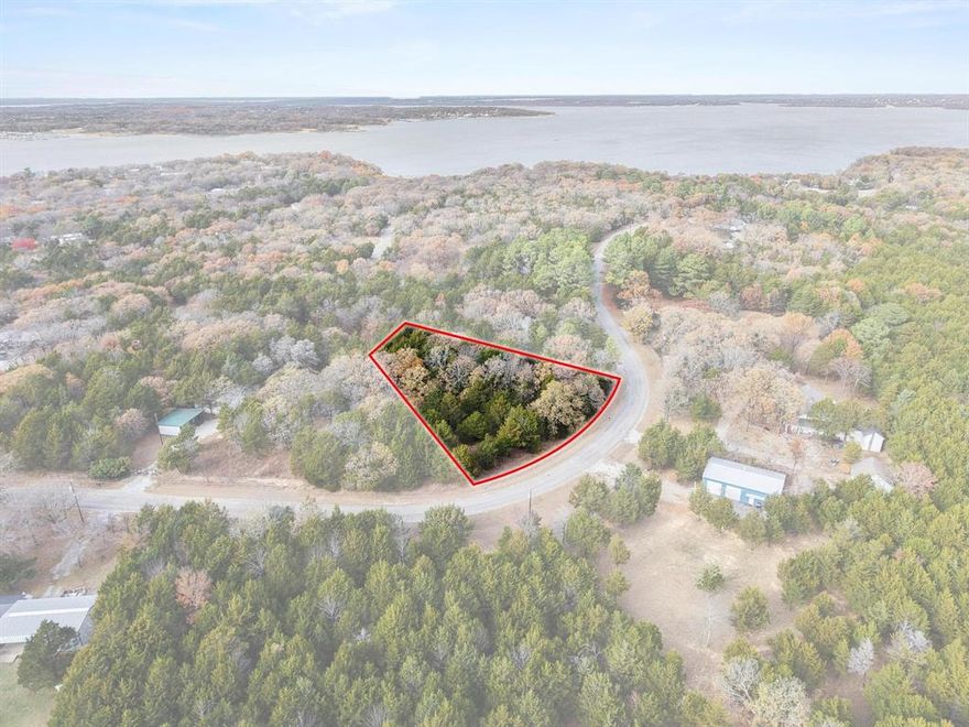 A rare opportunity near Lake Texoma — where privacy, nature, and lake life come together. Nestled in the desirable Mill Creek Homesites area of Pottsboro, this beautifully treed 1-acre corner lot offers a peaceful, elevated setting just moments from the water. Surrounded by mature hardwoods and evergreens, the property provides natural privacy while still capturing the essence of the Lake Texoma lifestyle.

From the aerial views, you can truly appreciate the rolling terrain, established neighborhood, and proximity to the lake, making this an ideal location to build your custom home, weekend getaway, or long-term retreat. Enjoy the convenience of being just a short golf cart ride to Mill Creek Marina, with multiple neighborhood beach access points within walking distance — perfect for swimming, relaxing, or soaking in sunset lake views.

Located in the Pottsboro School District and offering no known restrictions, this lot gives you the freedom to design and build at your own pace, with room to create the outdoor spaces you’ve been dreaming of.

Quiet, scenic, and perfectly positioned — this is your chance to own a slice of Lake Texoma living with the space and flexibility today’s buyers are searching for.