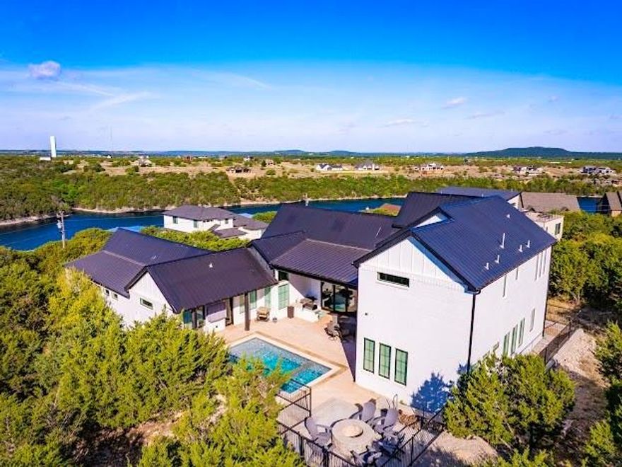 STUNNING 3632 sqft, 4bd,4ba, FURNISHED CUSTOM LAKE HOME on 2 LOTS in the Exclusive Amenity Rich CLIFFS RESORT on PK Lake with Golf Course, Pro Shop, Restaurant, Marina, Community Pool, Fitness Center, Tennis Courts and Playground. This 2023 Open Concept Design, Build Home, Features a Gourmet Kitchen with Stainless Appliances, Quartz Counters, Island, and Dining area, Living Room with Gas Fireplace & Wet Bar, All with Majestic Tall Ceilings, and Picture Windows throughout, enhancing the Natural Light of the rooms, with Patio Doors that open out to the Outdoor Living Center for Grilling, Dining, Entertaining, Relaxing and Watching Sports & Movies Poolside. The Primary Bedroom & Bath are conveniently located on the Main Floor with Walk In Closet, as are 1 Guest Bedroom and 2 Laundry Rooms. Then on the 2nd Level, there are 2 more Guest Bedrooms with Loft Living Room, Media Area that can serve as a  5th Bedroom as well.  Outside the Heated Gunite Pool, Spa Combo and Covered Patio areas, have Lovely Rustic Views and Privacy since the Sellers also bought the additional adjacent Lot next door, plus there's a Fire Pit for those cool Lake nights, for making Smore's and gazing at the Amazing Tx Starry Nights and Spectacular Sunset Colors. Poolside there is also an Outdoor Kitchen with Traeger and Blackstone Grills, Dining table and chairs set up, and 2 Mounted TV's. This is PK Resort Lake Living at it's Finest. There is also a 2 Car Garage, and 1 Golf Cart, ATV  Garage for Storage, and the Marina is located just down the road, for Lake Access and Sandy Beach Fun. Also Famous Hell's Gate is located just around the Corner on the Lake as well. Don't miss this Fabulous MUST SEE Lake Home.