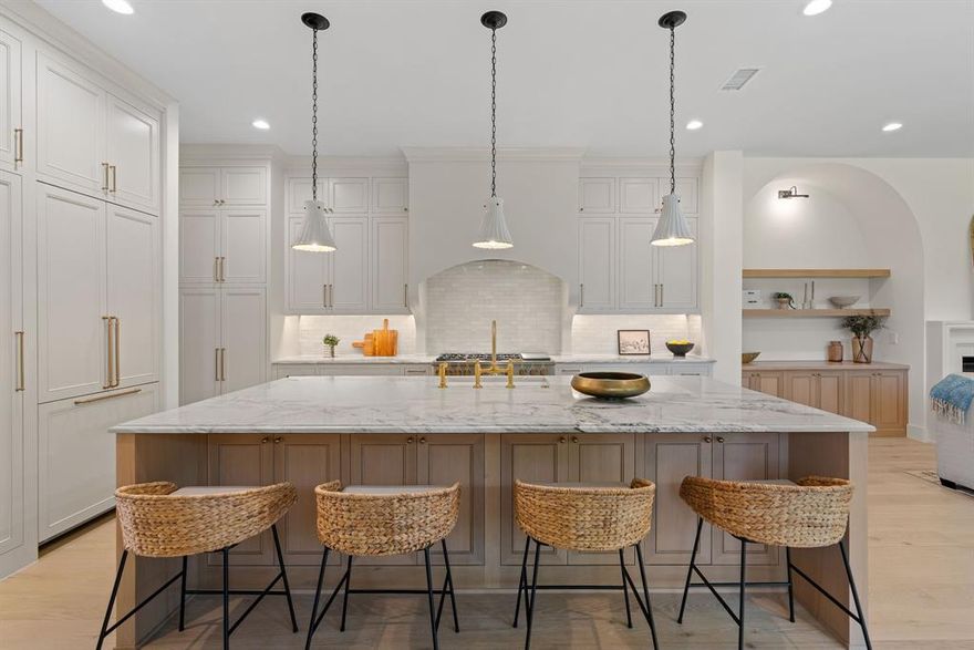 From the moment you arrive, the striking architecture of this Transitional Modern residence with Tudor inspired elements creates an unforgettable first impression. Inside, soaring ceilings, warm wood floors, and expansive windows fill the home with natural light, creating an inviting and elegant atmosphere.

The heart of the home seamlessly connects the kitchen, living, and dining spaces, designed for both everyday living and entertaining. The oversized island naturally becomes a gathering place, while the chef’s kitchen features panel ready appliances, a 48 inch range, designer finishes, and custom details throughout.

Whether hosting by the fire or enjoying a quiet evening at home, the space feels both grand and comfortable. A private study offers the perfect work from home retreat, while the nearby wet bar makes entertaining effortless.

The primary suite is a peaceful escape with a spa inspired bath featuring calming textures and luxurious finishes. Every detail of this custom 2026 residence was thoughtfully designed to create a home that feels sophisticated, welcoming, and truly exceptional.