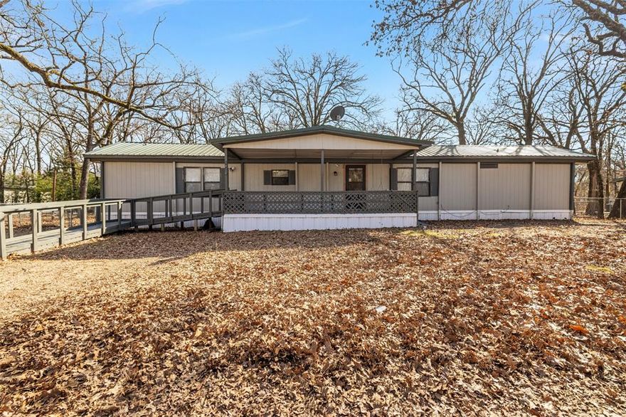 Well maintained 3 bedroom, 2 bath home situated on three spacious, tree shaded lots offering extra privacy and room to enjoy the outdoors. This inviting property features a large covered front porch and a spacious back deck ideal for entertaining. Two storage sheds provide plenty of space for tools, lawn equipment, or hobbies. Inside, you'll find an open concept living, kitchen, and dining area with a functional layout and comfortable flow. Updates include paint, carpet and double pane windows. A split bedroom arrangement provides added privacy, with generously sized bedrooms and spacious bathrooms. Conveniently located with lake access available through the HOA boat ramp, this property combines comfort and outdoor enjoyment perfect for full-time living or a weekend retreat.