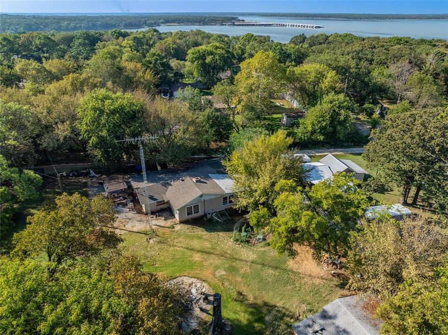 Lake Texoma Opportunity! Your blank canvas on nearly an acre of paradise. Imagine waking up and taking a short stroll to the shores of Lake Texoma, this incredible property makes it a reality! Situated in the sought-after Paradise Acres Subdivision, this unique offering features 0.85 acres across two lots, providing plenty of space and privacy rarely found this close to the lake. The existing structure is a spacious 4-bedroom, 2-bathroom frame home displaying over 3,000 square feet with a solid foundation and excellent potential. Inside, you'll find an expansive, open-concept layout that’s perfect for entertaining, featuring a cozy fireplace and a combined kitchen, dining, living area. Plus, there are a couple of outbuildings for extra storage or a workshop. This is the investment you've been waiting for! Priced attractively for a quick sale, this property is a prime opportunity for a savvy buyer, flipper, or anyone ready to customize their dream lake home. Bring your vision and elbow grease! Offered and priced AS-IS. Don't miss out on this chance to secure a sizable piece of Lake Texoma living.