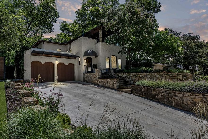 This immaculately updated and preserved 1938 Santa Fe-style home blends timeless character with thoughtful updates, just blocks from TCU and under a mile to Colonial Golf Course. Perched on an oversized, tree-filled lot, the property boasts lush, meticulously landscaped grounds and sweeping westward views of Fort Worth—best enjoyed from the covered rooftop patio. A true standout feature: the 12-inch thick Texas limestone walls, both inside and out, offering unmatched charm and a quiet retreat from the outside world. Step inside to a warm, inviting living and dining area anchored by a striking custom stained glass window and framed by a vaulted pine ceiling. 
The spacious owner's suite—added in 2016—sits at the rear of the home for extra privacy and overlooks the beautifully designed outdoor living space. It features a spa-inspired bath plus a generous walk-in closet.  The cozy family room between the owner's suite and the kitchen provides another space to relax or stream entertainment away from the main living. The kitchen is a dream with an efficient layout, premium 6-burner Wolf range, and serene backyard views that keep the cook connected to the home’s natural surroundings. The adjacent cozy den is ideal for relaxed evenings or casual entertaining.  Upstairs you’ll find two oversized bedrooms filled with natural light and a second full bath. Don’t miss the rooftop retreat—a one of a kind covered deck with panoramic city views, perfect for sunset lounging or morning coffee.  The backyard living space was completely reworked and landscaped in 2024, providing both sun and shade areas.  There is also a private courtyard on the far side of the home with a wood burning firepit. Every room in the house features views of the magnificent outdoors landscape.  Don't miss this unique home, which is located conveniently to downtown, shopping, and entertainment in Fort Worth!