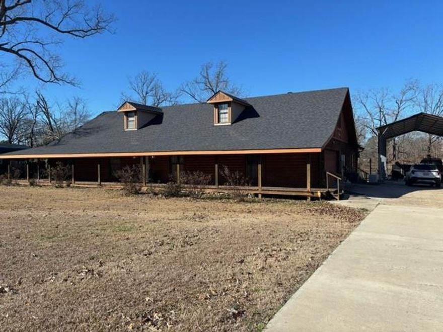 Stunning LOG HOME nestled on 1.5 acres with a blend of rustic character and modern updates. In the desirable North Desoto school district. Enjoy the beauty of nature with your own pond while relaxing on the back porch, swimming or fishing! The amazing porch wraps around 3 sides of the house. New roof in 2024. Fully open living room kitchen floor plan. Excellent for entertaining. Wrap around breakfast bar and separate dining area. Several recent upgrades, NEW oven, cook top, dishwasher and flooring. NEW quarts counter tops in kitchen and both bathrooms. Fabulous stone fireplace brings coziness and warmth to any gathering. Perfect bonus room off from the kitchen and living room for your office, playroom or craft space. Primary bedroom is remote with en-suite bathroom, large walk-in shower and closet. Complete 355 sq ft bonus room above the garage that can also serve as a home office, guest space, or hobby room. Covered RV parking space. Large outdoor workshop and storage building with electricity. Also wired for above ground pool. Gym set is ready to play on.  With the warmth and charm of log construction, modern conveniences and plenty of outdoor space to enjoy, this property offers a peaceful retreat while still providing the comforts of updated living.
