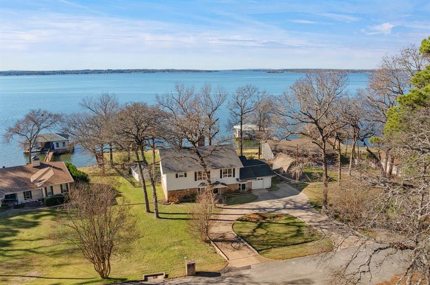 Welcome to lake life done right on beautiful Lake Palestine! This thoughtfully remodeled two-story home offers five spacious bedrooms, three full bathrooms, two half baths, and a dedicated office designed for comfort, connection, and easy everyday living. The open-concept main level was reimagined to highlight the stunning water views and natural light, featuring new LVP flooring, fresh paint, updated trim, smooth ceilings, and LED lighting throughout. The kitchen includes new cabinetry, quartz countertops, stainless steel appliances (all included), a spacious eat-in island, and a dining area that makes every meal feel special with the lake just beyond the windows. The main level features a peaceful primary suite with beautiful lakeviews, a soaking tub, walk-in shower, and generous walk-in closet. Also on the main floor are a private office, an additional bedroom with an attached half bath, and a large laundry room with a pantry and a convenient full shower bath, perfect after a day on the water. Upstairs offers impressively large bedrooms with double-deep closets, a flexible Jack-and-Jill bathroom layout featuring two large vanities and two toilets, multiple extra hall closets, and a NEW upper-level HVAC system (2025).Outside, this calm and open stretch of Lake Palestine is ideal for boating, fishing, tubing, and water sports. The rebuilt boathouse (2024) features a two-boat slip with a new hoist motor and cable. Additional upgrades include a NEW roof (2024),repaired retaining walls, rebuilt sprinkler system, vinyl shutters, a LARGE storage building for lake gear, and an attached one-car garage. With generous living spaces, meaningful upgrades, and unforgettable lake views, this is a place made for gathering generations together, relaxing, and making lasting memories
