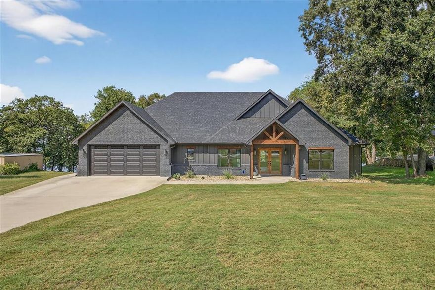 Enjoy unmatched lakefront living in this custom home on Lake Fork, finished in 2022. With stunning water views, a 50-foot pier, and a retaining wall, you can design your own boathouse. The grand living room features vaulted ceilings, wooden beams, a gas fireplace, and wall-to-wall windows overlooking the lake. The open kitchen boasts a large island, large butler's pantry, and wood countertops, perfect for entertaining. A spacious dining area opens to an expansive covered patio, ideal for gatherings. The luxurious master suite offers breathtaking views, a spa-like bath with soaking tub, custom shower, and large master closet connected to the utility room. Four additional bedrooms and a dedicated office provide ample space. The exterior combines painted brick, Hardie siding, and cedar accents for timeless appeal. A 12x16 storage building completes the backyard. Wake up to panoramic views and enjoy peaceful evenings by the water in this dream home!