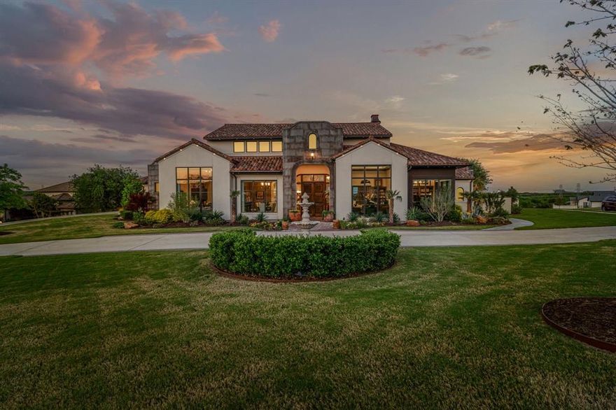 Situated within the prestigious, guard-gated enclave of La Cantera at Team Ranch—one of Tarrant County’s highest elevations—4925 Arbol Court is a masterclass in refined, single-story living. Just 15 minutes from downtown Fort Worth, this stunning estate sits on over an acre, seamlessly blending luxury, privacy, and effortless indoor-outdoor flow. A resort-style pool, elegant entertaining areas, putting green, and lush landscaping create a backyard retreat designed for both relaxation and celebration.

Inside, the thoughtfully designed layout balances grand entertaining and intimate comfort. Off the foyer, a formal dining room is set opposite a private study and music room—ideal for work or creative pursuits. The main living area stuns with a wet bar and floor-to-ceiling glass doors that frame sweeping views of the backyard oasis, flooding the home with natural light.

Anchoring the home is a chef’s kitchen featuring a brick barrel ceiling, large center island, cabinet-faced appliances, pendant lighting, and an adjacent prep kitchen for added storage and function. The owner’s suite offers a serene escape with a sitting area, coffee bar, statement feature wall, and direct patio access. A private hallway leads to the spacious laundry room for ultimate convenience.

A separate guest bungalow—accessed via the covered patio—boasts a living room, bedroom, full bath, walk-in closet, and private patio. Two additional guest suites offer ensuite baths, walk-in closets, and adjacent living areas for added privacy.

Built by Windmiller Homes in 2021, this estate combines timeless elegance with modern amenities. Beyond its gates, La Cantera offers walking trails, a private lake, and proximity to Fort Worth’s top private schools, dining, and cultural destinations. Welcome to 4925 Arbol Court—where sophistication meets sanctuary.