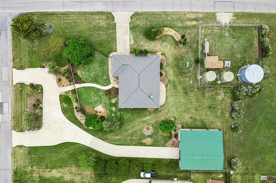 Perfectly situated on over one acre corner lot in the highly sought after community of Sun Valley Estates, this meticulously maintained property has it all. A stunning, elevated homesite framed by extensive manicured landscaping & a classic wrought iron fence. The expansive green space, gardens, & serene sunset views offer the perfect backdrop for outdoor living and show pride of ownership. Main home features 3 generously sized bedrooms, a lovely secondary bath & wonderful storage. The Spacious primary suite features warm wood flooring, vaulted ceilings, & abundant natural light. Spa-inspired primary bathroom featuring dual vanities, a relaxing jetted soaking tub, glass-enclosed shower, & oversized walk-in closet. Beautifully updated kitchen showcases custom-painted cabinetry, rich granite countertops, and a modern mosaic backsplash. The thoughtfully designed layout offers a center island, abundant storage, and seamless connectivity to the main living space—perfect for both everyday living and effortless entertaining. The living room is anchored by a warm brick fireplace and expansive windows that fill the room with natural light. The open-concept design flows effortlessly into the dining area, while durable tile flooring and neutral tones create a timeless, comfortable setting for both relaxing and entertaining. A secondary living space is a wonderful option for a formal den or home office. Impressive, oversized shop measuring approximately 30x52, offering exceptional space for a workshop, storage, or hobby use. The shop includes a private half bath for added convenience and functionality, a 12-foot door, & two 50 Amp plugs for RV & hot tub. Attached is an expansive covered patio overhang, creating the perfect setup for outdoor workspace, equipment coverage, or shaded entertaining. This property offers ideal country living while still having easy access to shopping, dining, & entertainment. Zoned to Award Winning Northwest ISD Schools this home is truly a must see.