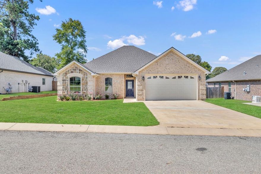 Welcome to Nolan Farms—a postcard-worthy community where East Texas charm meets modern comfort. This thoughtfully designed 3-bedroom, 2-bath brick and stone home offers stylish curb appeal and everyday functionality with a 2-car garage, front and back sprinklers, and a 6ft wood privacy fence with dual gates. Step inside to vaulted ceilings in the living room and third bedroom, custom cabinetry throughout, and upgraded finishes like granite countertops, vinyl plank flooring, and Roman arch doors. The primary suite features His & Hers closets, a garden tub, and a tiled walk-in shower with bench. Enjoy outdoor living with tongue-and-groove stained porches, an outdoor fan, and lighting for evening relaxation. Energy-efficient Low-E vinyl windows, upgraded lighting and plumbing packages, and Whirlpool stainless steel appliances add even more value. As a resident of Nolan Farms, you’ll love the beautifully landscaped entrance, future pavilion with restrooms, a stocked fishing pond, playground, and picnic space—perfect for family gatherings and community fun. Experience serene country living with modern perks in this inviting home.