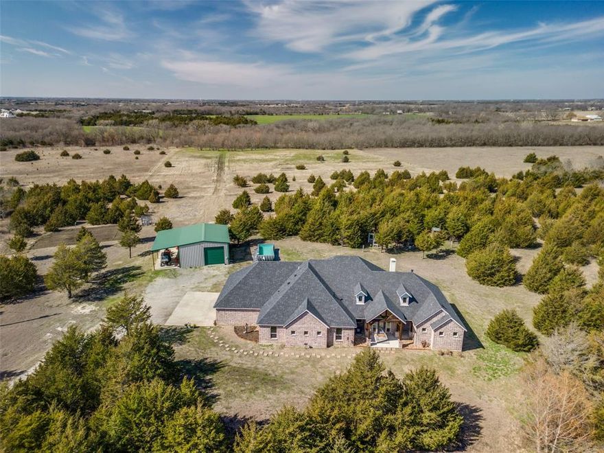 Within 5 Miles of Highway 121 and 78, just east of Melissa TX.  Stunning custom modern farmhouse on 20.498 acres of partially wooded land and open pasture in Collin County. This home is a true masterpiece, blending rustic charm with modern conveniences. Designed with high ceilings and an open, flowing floor plan with beautiful views of the property. Gourmet kitchen features custom slide-out shelving, three ovens, and a six-burner stove. The primary suite is a luxurious retreat, complete with an oversized air bathtub and a huge walk-in dual shower. Throughout the home, energy efficiency is a priority with foam insulation and a tankless water heater. This smart home-ready property offers indoor and outdoor surround sound, video, and audio capabilities. The oversized garage provides ample space for a boat or 3-5 vehicles, ensuring plenty of storage. Step outside to a beautifully designed outdoor living area, perfect for entertaining or simply relaxing in the serene country setting. Enjoy the natural beauty and privacy of this expansive property, complete with a pond, creek, and abundant wildlife. The 30x40 outbuilding is ideal for multiple uses and includes a covered space, and a room with bathroom hookups, perfect for a workshop, guest quarters, or extra storage. With bow hunting allowed, this property offers a one-of-a-kind lifestyle, combining modern amenities with the tranquility of country living. A must-see to fully appreciate all it has to offer! Schedule your private showing today!