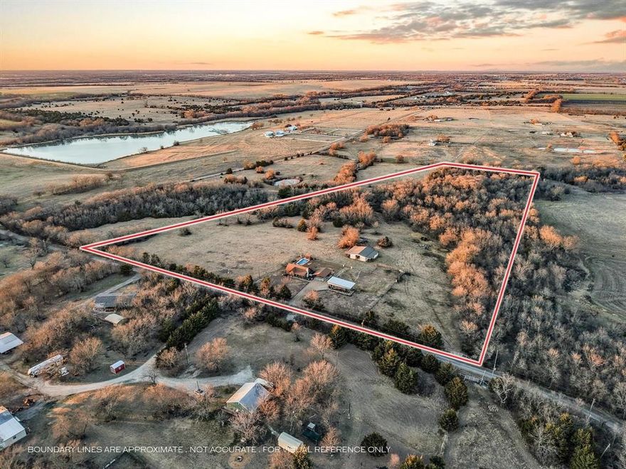 OPEN HOUSE ~ Sat. 3.14.26, 2pm-4pm ~ Experience the ultimate Texas sunset from this private 18+ acre oasis. Whether you’re soaking in the hilltop pool, unwinding on the expansive patio, gathered around the firepit, or relaxing in the hot tub, you’ll enjoy evening panoramic vistas that put you front-row to the best show in North Texas.
Bathed in natural light & curated with impeccable style, this breathtaking home offers sweeping views that create the perfect backdrop for everyday living. Designed for seamless indoor-outdoor flow, the open-concept layout centers around a striking stone fireplace, creating a warm, inviting atmosphere that opens effortlessly to multiple outdoor entertainment spaces. The kitchen offers endless counter space & large island with seating making hosting a breeze, flowing into a dramatic dining area with soaring ceilings & a picture window frames stunning pool & ranch views. The home was originally designed as a three-bedroom & has been thoughtfully converted to a spacious two-bedroom layout, enhancing the living areas while maintaining comfort & functionality. Two generously sized bedrooms & two full baths provide quiet retreats to end the day. Detached flex space offers excellent versatility & would make an ideal home office, gym, studio, or creative workspace. The courtyard extends across the back of the home, leading to a hot tub, sauna, & fenced pool area—perfect for relaxation & entertaining. Outdoor amenities include a covered RV area with water and a 50-amp hookup & designed to be easily converted into a full-size pickleball court, an impressive six-stall metal barn with wash rack, tack room, electricity, & water, plus a nearby corral with water access. Pastures are fenced & cross-fenced, complemented by a stock tank & mature trees. Currently ag-exempt, this ranch is comfortable, functional & ready for your livestock. This isn’t just a ranch—it’s a lifestyle.