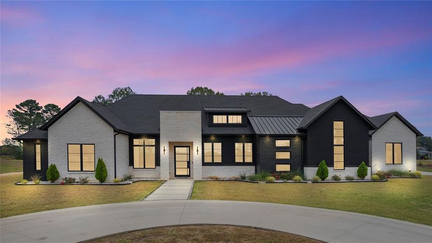 This striking modern home on 11 acres makes a statement from the moment you arrive. Its bold exterior of contrasting brick, stone, and sleek black stucco sets the tone for the sophisticated design found throughout. Inside, the open-concept layout showcases a stunning kitchen with custom cabinetry, quartzite countertops, high-end appliances, and designer lighting that flows into a spacious living area accented by vaulted ceilings and a modern fireplace. With 4 bedrooms, 3 baths, and a dedicated office with a closet (optional 5th bedroom), this home is thoughtfully designed for flexibility. Every detail — from the clean architectural lines to the wood tones — reflects careful craftsmanship in this custom-built home. Step outside to enjoy the inviting outdoor living area featuring a covered patio and full outdoor kitchen. This property beautifully combines modern luxury with tranquil country living.