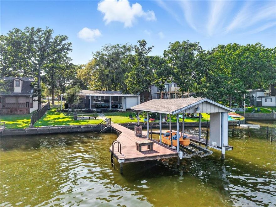 Life is better on the water, and this Cedar Creek Lake home is designed to make the most of it. Tucked into a premier fishing cove, it was fully remodeled in 2021 and has been meticulously maintained. Outdoor living shines with an expansive 19’x40’ covered patio, outdoor kitchen, and fire pit; perfect for gatherings after a day on the lake. The private covered boat slip comes equipped with a metal cradle, updated cables and pulleys, and a remote-controlled Sunsetter shade, with approximately 10’ of water depth at the dock. A boat ramp just one block away adds extra convenience. With ample parking, a 10’x18’ storage building, proven short-term rental income, and the seller's intent to convey the home fully furnished, this property is equally suited as a turnkey investment, weekend retreat, or full-time lake home.