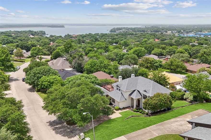 SELLER IS OFFERING A $10,000 CONCESSION WTH ACCEPTABLE OFFER! This beautifully updated three-story traditional is tucked away on a hard to find lot in the sought-after Lake Country Estates - offering a secluded retreat surrounded by mature trees & nature-inspired surroundings—all just minutes from city amenities. This home features 4 spacious bedrooms, 4.5 bathrooms, complemented by wood flooring in the main areas, and walls of windows that bathe the interior in natural light while framing breathtaking sunset views over Eagle Mountain Lake. Three unique outdoor areas include: a newly remodeled, extra-large balcony deck with Italian-style wrought iron banisters & 25-year engineered composite pavers, a shaded walkout patio off the basement, and an outdoor area is a full-size wooden deck overlooking the backyard with a gas tap for an outdoor kitchen, also with views of the lake! The walkout basement, freshly updated with new paint, flooring, drywall, and carpet, includes a half bath with new fixtures, perfect space for a rumpus room, media-game room, or bring your HGTV dream ideas to life! This chef's kitchen boasts quartz countertops, Italian designer tile mosaics, and an oversized walk-in pantry, while the expansive main living room offers skylights & a welcoming WBFP. Highlights include a separate home office with French doors, and an oversized laundry room with dual sinks. Upstairs, the owner’s suite provides private access to the balcony with lake views. 2 additional bedrooms, 1 offering its own private ensuite & the other bedroom has direct balcony access. Large U-shaped driveway with space for 3+ additional vehicles, an extra-large 2 car garage with built-in shelving, pegboard walls, and ample storage with both a large outdoor shed & a smaller utility shed. Updates: A new HVAC system (2024), new ductwork, roof (2022), vinyl double-pane windows, piered main slab, recently painted & stained the back deck, fresh landscaping & French drains.