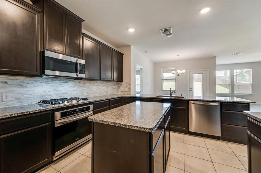 Nestled in the highly sought-after Villages of Melissa community, this captivating two-story home boasts 5 bedrooms and 4 baths. The focal point is the beautiful family-sized kitchen featuring expansive granite counters and a gas cooktop, overlooking the dining area and family room adorned with a fireplace. It's open floor plan effortlessly caters to entertaining needs. The ground floor hosts a spacious master retreat with separate vanities, a large shower, separate tub, and an expansive walk-in closet. Additionally, there's a convenient bedroom and bath downstairs. Upstairs, discover 3 bedrooms, 2 baths, and a delightful game room. Outside, a vast backyard awaits with a covered patio, offering ample space for outdoor activities. This master-planned community offers beautiful greenbelts, parks, a community pool, and playgrounds, enriching the living experience. This home combines functionality and style,  perfect for those seeking a  comfort and entertainment in a vibrant community