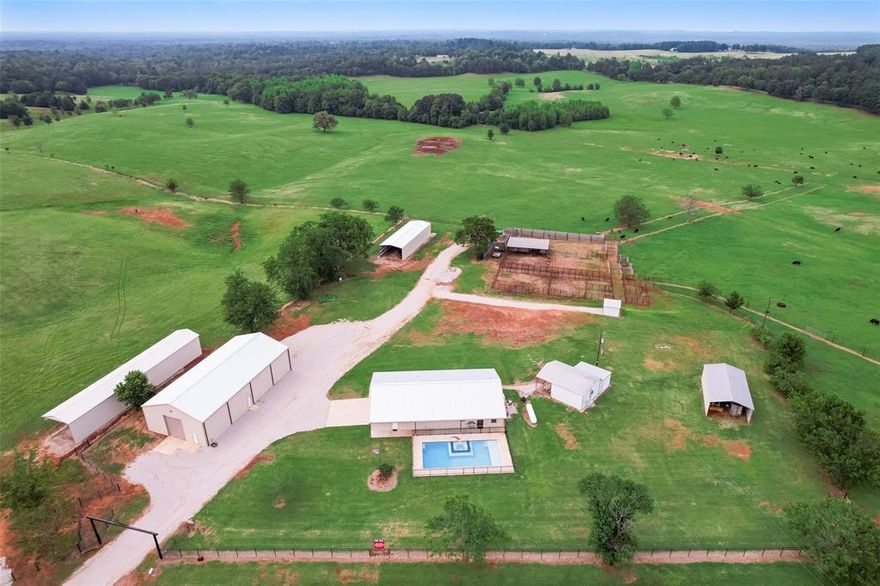 This East Texas Ranch with its gorgeous rolling grazing pastures offers secured gated entry with pipe fencing frontage is fenced & cross fenced. The 2562 SF custom Barnodominium offers open living spaces,a custom kitchen with stainless appliances & serving island, 3 spacious bedrooms & 2 baths with custom finish out, a whole house generator & offers lots of storage along with a 10 ft. deep pool & spa surrounded by iron fencing. The oversized garage has epoxy floors.  The ranch has full working pens & squeeze chutes with functional gate system for an efficient working cattle Ranch that will sustain 100 head of cattle year around. Community water serves the residence & improvements but there is also a 200 ft. water well that provides livestock water to 6 troughs throughout the ranch & a large spring fed pond. Improvements include a 3230 SF shop bulding, 1920 SF hay barn & 880 SF equipment shed as well as 440 SF Bunkhouse. Fabulous consideration as a full time home or a weekend getaway.