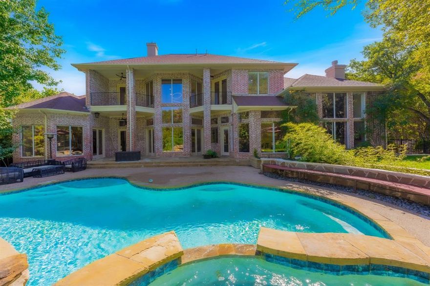 Elegant custom-built 5,143 sq. ft. East facing estate on a heavily wooded 1-acre lot in a neighborhood of all custom homes. Recently remodeled with fresh white interiors, upgraded bathrooms, and modern kitchen updates, this home blends luxury with comfort in a serene, resort-like setting.

Featuring 4 bedrooms and 5 baths, soaring ceilings from 11’–24’, and abundant natural light, the interior is designed for both daily living and entertaining. The family room boasts a sleek modern fireplace and Turkish lighted shelves, while the formal living room includes a gas fireplace with views of the pool. The chef’s kitchen showcases Italian porcelain countertops, high-end appliances, and upgraded refrigerator and microwave. Two wet bars, one with a built-in wine fridge, add convenience. A luxury theater comes fully furnished with Sony 4K projector, Marantz processor, 9.3 speaker system, and wet bar. A professional gym with treadmill, weights, Echelon Mirror, bike, and rowing machine is also included.

The master suite is a retreat with wooded views and a spa-inspired bathroom featuring quartz finishes, walk-in shower, and a hot water jacuzzi. Two upstairs bedrooms include private balconies. Flooring includes Italian marble and hand-scraped hardwood, with carpeted theater for comfort.

Outdoor living includes a pergola and full outdoor kitchen with Evo flattop grill, pizza oven, 4-burner stove, fireplace, ice chest, and island seating for 12. The resort-style pool and spa are app-controlled and come with a $2,000 robotic pool cleaner. Flowerbeds at entry flow seamlessly to the pergola and pool.

Eco-friendly with LED lighting, energy-efficient HVAC and appliances, double-paned windows, and mature trees providing natural shade. Extras: 3-car epoxy garage, automated irrigation, five storage closets, and a fruit-bearing fig tree.