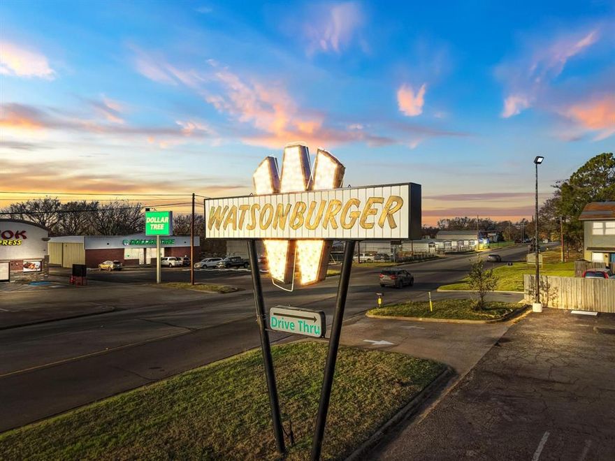 As the flagship performer in the Watson Burger portfolio, 1901 W. Morton St. stands at the highly visible corner of W. Morton St. (FM 120) and Juanita Drive, positioned perfectly for your next fast-food or full-service dining concept. With over 14,000 vehicles traveling Morton St. daily, this site delivers exceptional exposure along one of Denison’s primary commercial corridors. FM 120 serves as a direct connector between Denison and Pottsboro, the gateway to Lake Texoma—soon-to-be home of the Margaritaville and Hard Rock resort developments—driving consistent local and tourist traffic. The property is also just 1.4 miles east of Hwy 75, ensuring convenient regional access. Watson Burger is currently operational at this location, employing 7 staff members, seating 52 guests with additional seating capacity. The building retains the charm of its original sit-down design, with a rock-clad exterior, floor-to-ceiling windows, and a drive-through window added approximately 20 years ago. Infrastructure improvements include a 6-year-old commercial-grade vent hood and a 6-year-old TPO roof. The restaurant features a walk-in cooler, a walk-in freezer, a separate office, two bathrooms and ample on-site parking. At its peak, Watson Burger matched Whataburger’s regional popularity. Surrounding the property is a concentration of major national and regional retailers, reinforcing the area’s commercial draw. Nearby operators include Wok Xpress, Mama Qin, Dollar General, Dollar Tree, Chick-fil-A, CVS, QuikTrip, Starbucks, Burger King, McDonald’s, Walmart, Braum’s, Best Western, and other high-traffic convenience retail. The Sherman–Denison metro is experiencing unprecedented economic expansion, led by the $30B Texas Instruments semiconductor plant which just opened. 1901 W. Morton St. offers a turnkey opportunity in one of North Texas’s fastest-growing corridors—ideal for operators seeking visibility, traffic, and immediate market presence.