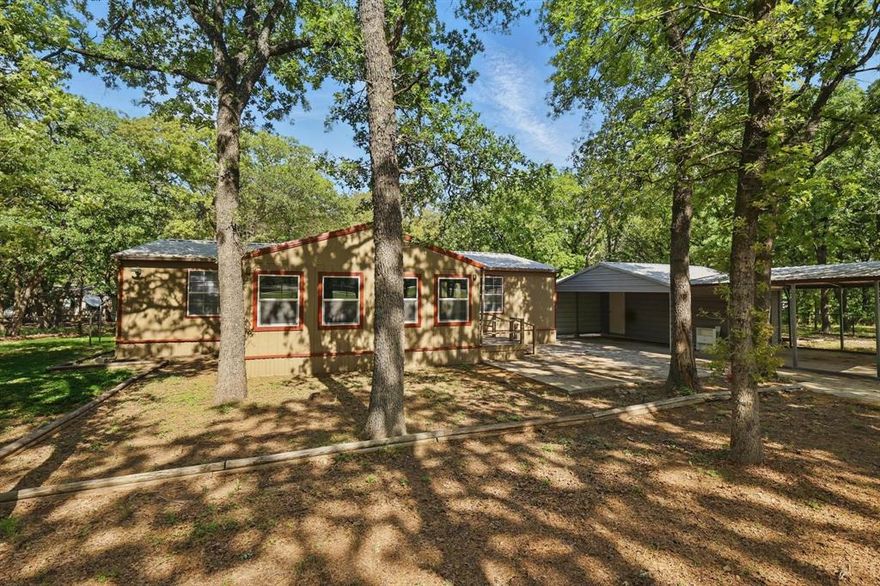 Fully fenced lot front & back covered in tall oak trees, 20 X 10 steel bldg. with 6 X 6 roll up door and attached 3 car carport, 10 X 12 wood workshop with covered porch & 2 doors with ramps. 23 X 22 open concrete patio in the front. Kitchen & bedrooms have been remodeled. Kenmore Elite oven, cooktop, dishwasher & microwave installed 2017. Metal roof in 2017. Water well drilled in 2015. Culligan water softener system added & HVAC replaced in 2016. 28 X 8 wood deck with ramp in back.