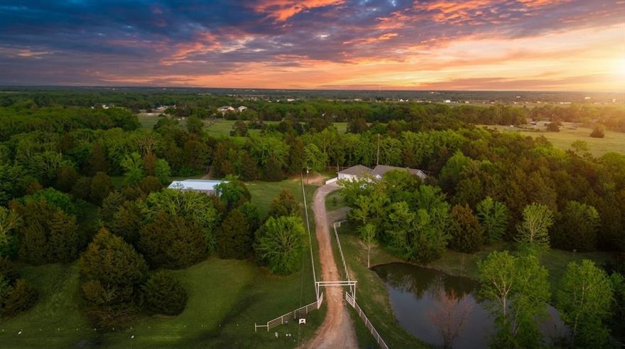 Enjoy the peace and quiet of country living on this stunning East Texas ranchette where beautiful open skies stretch endlessly overhead and peaceful evenings feel like a daily luxury! The entry has a double electronic gate with top rail pipe fencing outlined in no climb wire and the entire property is fenced and cross-fenced! A perfect blend of pasture and mature trees—ready for your animals and ideal for anyone seeking privacy and a slower pace! Ranch includes a truly custom-built, energy-efficient cottage-style home featuring a spacious 2,750-sq-ft open floorplan with 3 bedrooms, 3 full baths, office, and large upstairs bonus room, along with an attached 2-car garage. Inside, the inviting family room is wired for surround sound and showcases custom built-ins, a gas-log fireplace, and updated LVP flooring that flows throughout the main living areas. The Kitchen is light and bright boasting white painted cabinets, an island, breakfast bar, double-oven range, granite countertops, and a generous walk-in pantry. Split-bedroom layout enhances privacy, with the primary suite offering a double-sink vanity, jetted tub, separate shower, and a custom walk-in closet! Adjacent to the home is a matching 30x40 insulated building with 2x6 construction, OSB lining, water and electric, a half bath with dog-washing station, washer-dryer connections, and two dog kennel runs on the exterior—perfect for an additional garage, workshop, or hobby space! Out in the pasture additionally you have a 30x50 insulated workshop with 20x50 overhang providing ample room for equipment and hay storage. Through the cattle guard leading from the main drive, you will find a two-stall loafing shed with cattle-panel corral! Truly to many features to list! This property delivers the peaceful lifestyle you’ve been dreaming of while remaining close to the amenities the city has to offer situated just 5 miles East of Greenville, 25 miles to Rockwall, and just under 50 miles to Dallas! A must See!