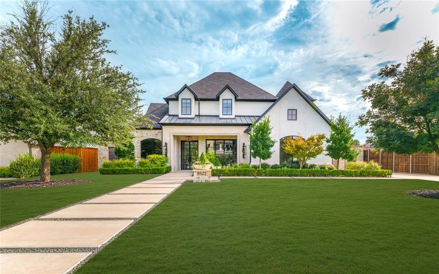 From the moment you cross the threshold of the oversized glass-and-iron doors, a sense of profound arrival takes hold, pulling you into an atmosphere where soaring 13-foot ceilings meet the inviting warmth of layered designer finishes. The heart of the home pulses with executive energy, anchored by the tactile richness of Taj Mahal quartzite and a glass-encased wine salon that transforms your collection into a sophisticated work of art. Every corner reflects curated prestige, from the elevated scullery that ensures seamless entertaining to the glass-walled office that serves as a transparent retreat for deep focus. Retreat to a primary suite that feels like a private veranda, where the soft glow of the hearth and premium Phillip Jeffries wallpaper create a haven of total seclusion overlooking lush landscaping and direct access to pool.  Outside, the environment is defined by the ambient glow of a designer fire feature and the sophisticated comfort of an al fresco oasis, offering a lifestyle of seamless indoor-outdoor luxury. This estate is a masterclass in modern living—a residence where every detail reflects a standard of uncompromising excellence.