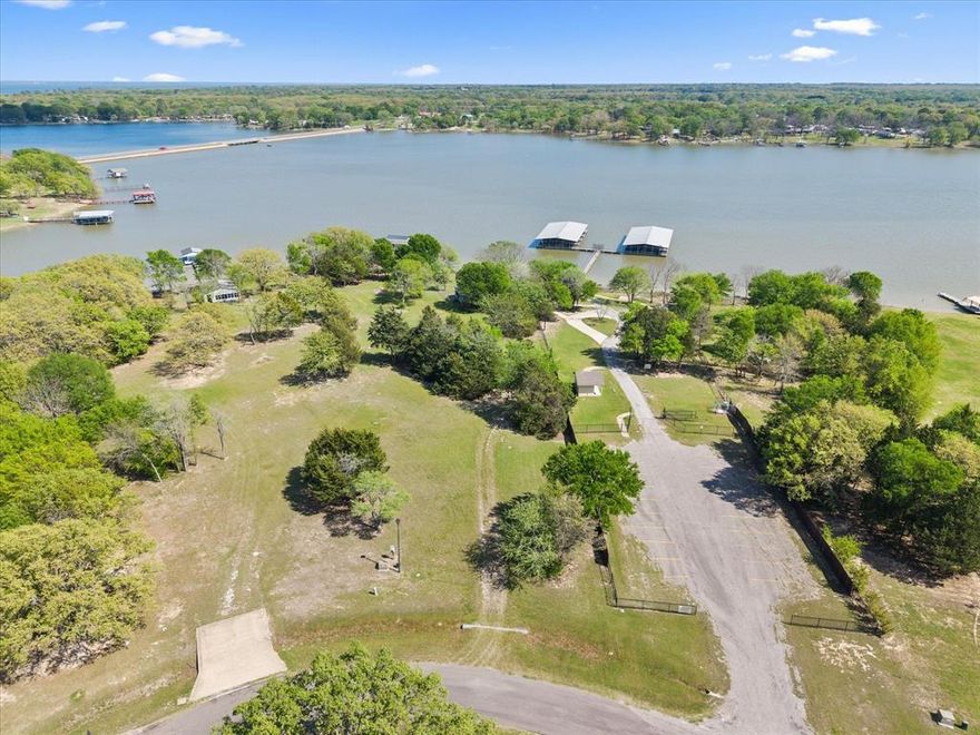 Rare opportunity to own .82 acre of deeded lakefront lot (plus an additional 1.2 acres of SRA ) comes with a fabulous boat dock for you boat and jet skiis and a day cabin to enjoy while building  your ultimate dream retreat. An additional .87 acres of deeded land and 1.2 of SRA leaseback lakefront property is also for sale (see MLS 2128832)  offering an expansive setting to bring your lakeside vision to life. Enjoy the existing day cabin that includes open floor plan with family room and kitchen,  small fenced yard, welcoming  veranda style porch, and convenient storage shed—perfect for enjoying the outdoors while you plan your future build. Please note: the cabin is not permitted for full-time living. Waterfront amenities truly set this property apart. Enjoy your private covered boat dock featuring one boat slip with an electric lift, ensuring your watercraft is always ready for the next adventure. The additional floating dock is ideal for fishing, kayaks, or relaxing by the water. Recently updated with durable metal siding and low-maintenance TREX decking, the dock blends style with longevity. An expansive 10’ x 28’ open deck provides the perfect spot to take in breathtaking sunsets or cast a line. Inside the cabin, you’ll find thoughtful updates including shaker-style cabinetry, granite countertops, an electric range, and refrigerator. Ceiling fans and solar screens enhance comfort during warm summer days. Residents enjoy access to the Waters Edge community amenities, including a gazebo, park, floating marina, restrooms, and ample guest parking—ideal for hosting family and friends. This is more than a property—it’s a lifestyle opportunity to create lasting memories in a peaceful lakeside setting. This is the one you have been waiting for! Ready for your summer fun!