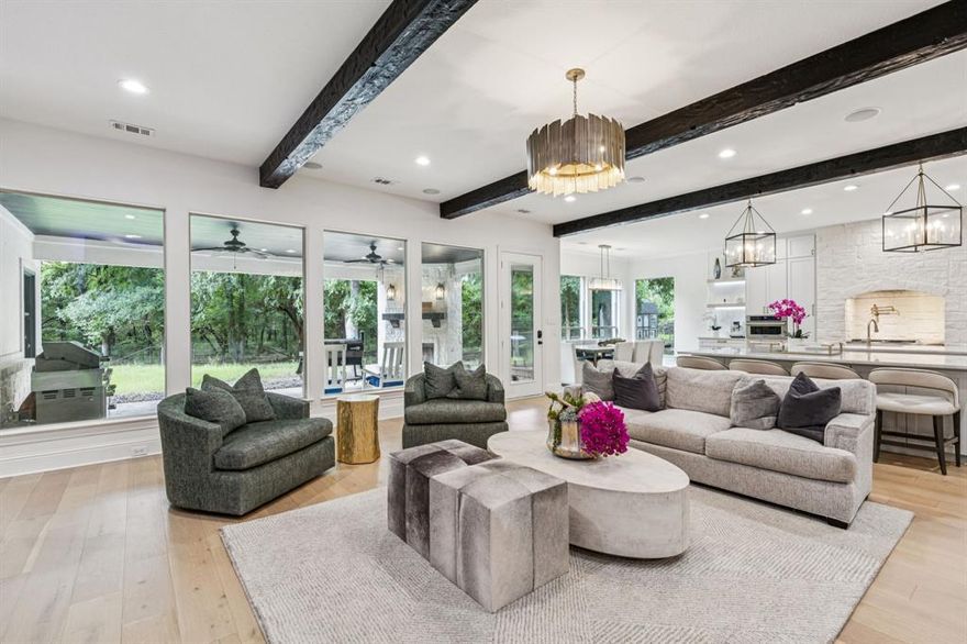 Price Improvement! Tucked behind a private drive on 6 stunning, wooded Ag-exempt acres in highly sought-after Celina, this exceptional estate offers luxury, privacy, and unmatched versatility. The thoughtfully reimagined home showcases custom design, open-concept living, and tranquil views throughout. The chef’s kitchen is a true centerpiece with soft-close cabinetry, dual oversized quartzite islands, a dramatic lime-washed stone range surround, full marble backsplash, built-in coffee bar, and champagne bronze fixtures. Designer lighting with under-cabinet and floor-level LED accents creates a warm, elevated ambiance. Waterproof wood flooring flows beneath exposed beams and expansive picture windows framing peaceful treetop views. The spacious living room features a striking whitewashed stone fireplace with dual media walls. A private study with built-ins conceals a hidden bonus room ideal for hobbies or secure storage. Outdoor amenities include a large insulated steel building plumbed for water and electric - perfect for a gym, workshop, RV or boat storage, or future barndominium. Additional highlights include a 27kW whole-home generator, Starlink high-speed internet, and SpringWell 3-stage water purification. Complete with a small barn, chicken coop, pond, seasonal creek, no HOA, and horse-friendly. Enjoy acreage living just minutes from Downtown Celina in acclaimed Celina ISD. Rare opportunity - schedule your showing today.