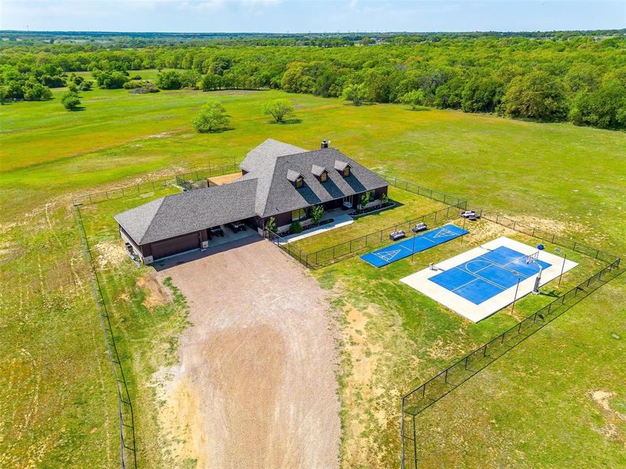 Welcome to this exceptional 42+- acre estate tucked away on the outskirts of Springtown. This remarkable ag-exempt property is a true gem, offering the perfect blend of luxury, country living, and development potential. Additional 53 acres available for purchase - MLS # 20908194. 
At the heart of the property lies a custom-built home featuring three bedrooms, three bathrooms, a game room, and a secret hidden basement with a walk-in gun safe. Designed for sustainability, it incorporates paid-off solar power, triple-pane windows, spray foam insulation, and meticulous engineering for maximum efficiency. 
Equestrian enthusiasts will appreciate the barn with four covered stalls with turnouts, an open-air lit arena tailored for team roping, and a covered arena for year-round use. Fully fenced and cross-fenced so bring all of your livestock! 
For those in need of space and versatility, the oversized shop includes a two-bedroom apartment, an air-conditioned gym, and ample covered parking for all of your toys and equipment. Additionally, an extra building with two bedrooms and a half-bath makes this property ideal for multi-generational living and screams FAMILY COMPOUND! 
Outdoor lovers will revel in the hunting and recreational opportunities with a scenic mix of trees, a creek, and two stock tanks. Become the ultimate party host with a Sports Court and Shuffleboard Court ready to be played on! Conveniently located with paved road access on both sides and two gated entries, this acreage also presents exciting development potential. 
Whether you're seeking a private retreat, a thriving agricultural estate, or a place for friends and family to call home, this property offers endless possibilities. Don’t miss your chance to own a slice of paradise in Parker County!