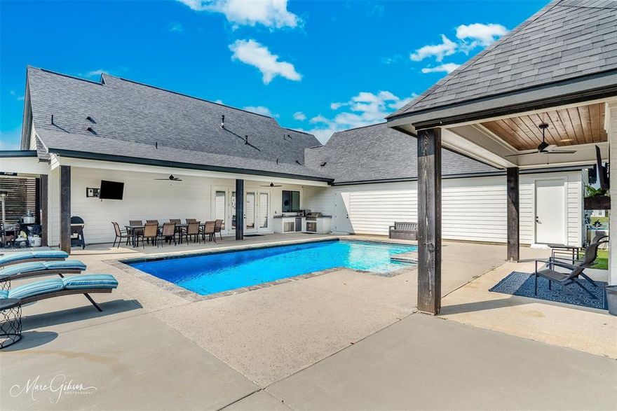 Welcome to your dream home — a like-new modern farmhouse designed for both everyday living and effortless entertaining. Nestled on 3.5 acres, this home blends comfort, charm and luxury finishes including sliding barn doors, custom wood rails and quartz in every bathroom. Inside, light-filled spaces feature shiplap walls, custom wood accents and durable wood-look tile flooring. The spacious living room offers abundant natural light, a cozy gas fireplace and built-in cabinetry with floating shelves. At the heart of the home, the kitchen dazzles with quartz countertops, a Z-Line cooktop, massive walk-in pantry, brick backsplash, oversized island with seating and soft-close cabinetry — all flanked by a welcoming dining area. Powder bath with shiplap and hexagon tile is perfectly located behind the kitchen, with access from the garage and pool area for added convenience. Downstairs flexible office or nursery. The private primary suite is a retreat, featuring a sitting area or reading nook. Its spa-inspired bath includes a massive subway-tiled walk-in shower, soaking tub and unique design touches inspired by an ancient bath house. Step outside to your own resort-style oasis: a heated chlorine pool with tanning ledge, a covered patio ideal for dining or lounging, and a full outdoor kitchen with sink, built-in grill, and mini refrigerator. An inviting cabana with fireplace — usable as either wood-burning or gas — completes the space. Pond is also on the property. Upstairs, two spacious bedrooms share a full bath, along with a versatile den perfect for relaxing or entertaining. The den includes a built-in Rycon interactive touch-screen system plus a second laundry. Walk-in attic access and extensive floored storage ensure space for everything. Additional features include a whole-home generator, custom window coverings, 4-car garage, natural gas, septic and plenty of space to add a shop or pool house. Tons of parking space, including for a RV. Schedule a private showing.