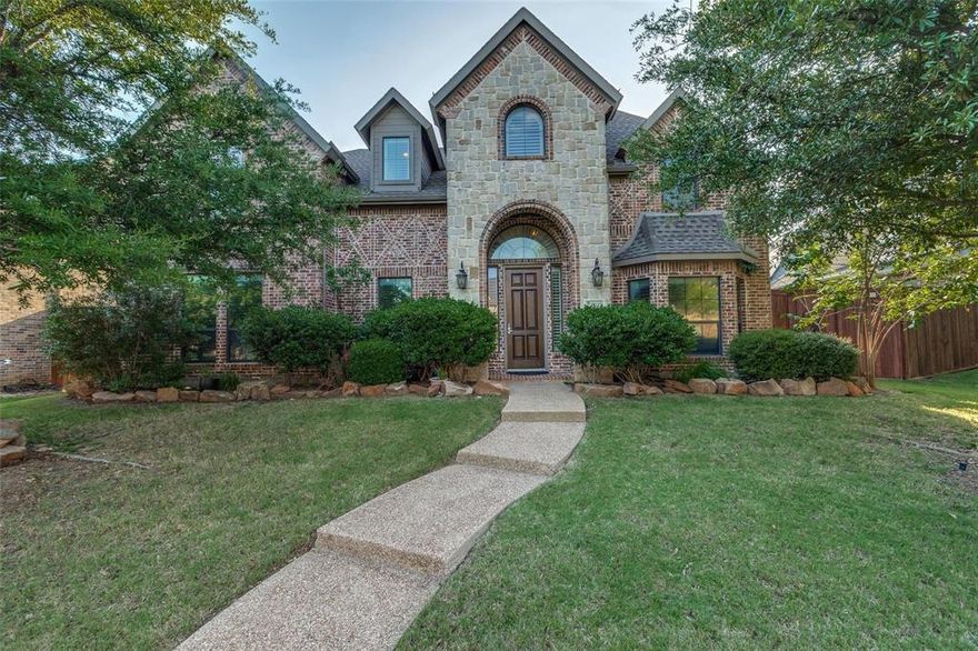 Beautiful traditional home located in the prestigious Shaddock Creek Estates in Frisco ISD. Hand scraped hardwood floors arched entryways and an elegant spiral staircase welcome you.  The spacious kitchen features granite counters, SS double ovens, microwave and dishwasher, rich wood cabinetry, butler's pantry and is plumbed for gas.  It is open to the living area which has a gas fireplace, built ins, 2 story soaring ceilings, Plantation shutters and an abundance of natural light.  A coveted feature is a guest bedroom and full bath on the first level.  The primary suite has a sitting area,
and a spacious bath featuring a tub, shower, dual sinks and a stone countertop.  Upstairs is a large game room with wet bar, a media room with a bonus room, a flex space, 3 bedrooms and 2 full bathrooms. Enjoy the outdoors on the stamped concrete patio with pergola.  Extra space and peace of mind provided by an electric gate for the 3 car garage.