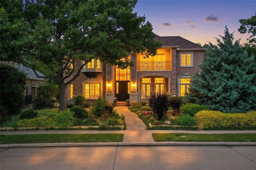 Nestled within the prestigious enclave of Lakeside on Preston, this 5,998-square-foot estate offers more than just a residence—it offers a lifestyle defined by elegance and natural beauty. Positioned on a premier lot with tranquil lake and park views, the home commands attention with its stately curb appeal. A deep, covered front veranda and a classic upstairs balcony overlook the tree-lined street, inviting you to enjoy the quiet rhythms of one of Plano’s most coveted neighborhoods. Upon entry, the home reveals its architectural pedigree through a grand staircase, soaring ceilings, and expansive windows that flood the space with light. The heart of the home is a designer kitchen balancing style and high-end function, featuring a six-burner Dacor gas range with double ovens, built-in refrigeration, and a back staircase for discreet access. This space flows into a breakfast nook that opens to a side patio, and a cozy den anchored by a fireplace and walk-in wet bar. For those who work or exercise at home, the property offers a rich wood-paneled study with French doors and a separate bonus room with hardwood flooring and mirrors, ideal for a gym. Upstairs, a massive game room features its own balcony, a second walk-in wet bar with a fridge and dishwasher, and ample space for a pool table. Adjacent is a dedicated media room for a true cinema experience. The primary suite serves as a private sanctuary, featuring a sitting area, a gas fireplace, and bay windows with direct patio access. The ensuite is a masterclass in luxury with dual vanities, a hydrotub, and a rare hidden safe room. Outside, the resort-style oasis has a heated pool and spa and a garden sitting area under mature trees. The covered patio offers a fireplace and built-in grill station to provide the ultimate setting for al fresco dining. With tons of storage, a large floored attic, and access to community lakes, trails, and tennis & pickleball courts, this home is a rare masterpiece of design and comfort.