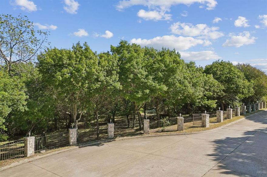 One acre residential lot that is heavily wooded with beautiful mature trees on a rolling terrain. Offering a park-like setting and a quiet, natural environment. The property is located at the end of a cul-de-sac lane, surrounded by custom executive homes. The lot is fully fenced, featuring a wrought iron fence with stone columns across the front. Conveniently situated near retail and restaurants, this location is the perfect combination of privacy and accessibility. A great opportunity to build in a peaceful, established neighborhood. There is no HOA, no required build time, you choose the builder and the property is not located in a floodplain. Don’t miss this rare find to meander down a tree-lined street and experience the tranquility and charm this special property has to offer.