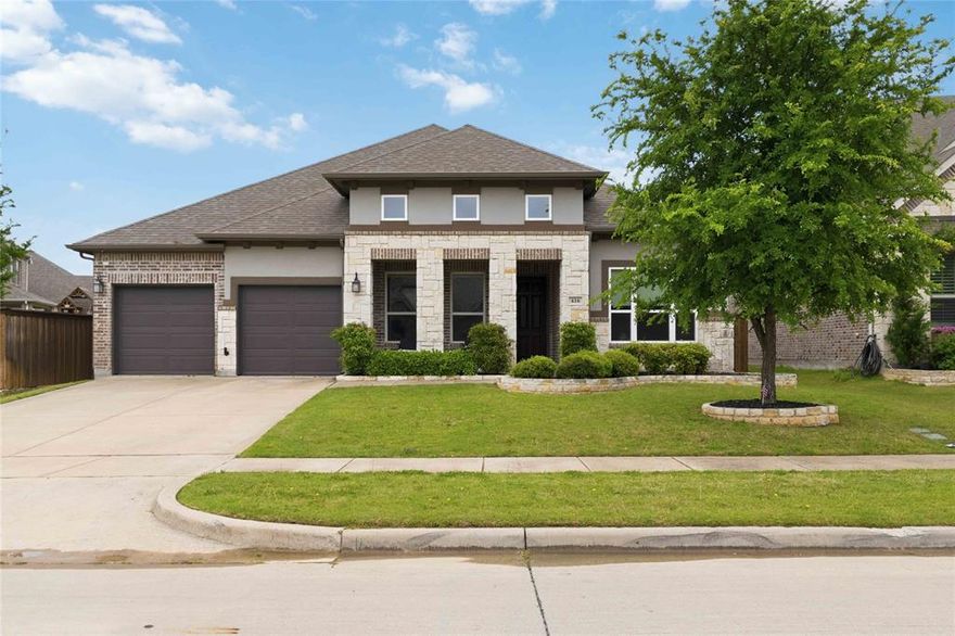 Experience refined living in this stunning custom home in Trinity Falls! Gracefully appointed on a premium lot w-an expansive, oversized backyard designed for both grand entertaining & everyday luxury. A timeless blend of brick, stone & stucco creates an unforgettable first impression, complemented by a welcoming front porch that sets the tone for what lies within. Inside, a richly appointed private study with a wood-paneled accent wall and serene front yard views offers a sophisticated work-from-home retreat. The formal dining room is elegantly scaled, ready to host memorable gatherings and elevated dinner parties. At the heart of the home, the grand living room impresses with a dramatic floor-to-ceiling stone fireplace, abundant natural light, and picturesque views of the sprawling backyard, seamlessly flowing into the designer kitchen. The kitchen is a true showpiece, featuring an oversized island with storage, striking triple pendant lighting, a gas cooktop with vent hood, double ovens, SS apps, custom cabinetry & a crisp white subway tile backsplash, perfectly blending style & function. Adjacent, a secondary living area provides a versatile space ideal for a game room or kids space, while a dedicated media room tucked behind solid doors invites immersive movie nights at home. The private primary suite is a tranquil retreat, enhanced by tray ceilings and a beautifully updated en-suite bath with dual sinks, framed mirrors, a separate shower + a renovated, boutique-style walk-in closet designed for luxury. Step outside to your extended covered patio, complete with a natural gas hookup, creating the perfect setting for outdoor kitchens and year-round entertaining. The expansive backyard offers endless possibilities, whether envisioning a resort-style pool, sports court, or lush garden oasis. This remarkable home masterfully blends intentional design, a striking & highly functional floor plan + designer finishes, all set on an massive lot that truly sets it apart.
