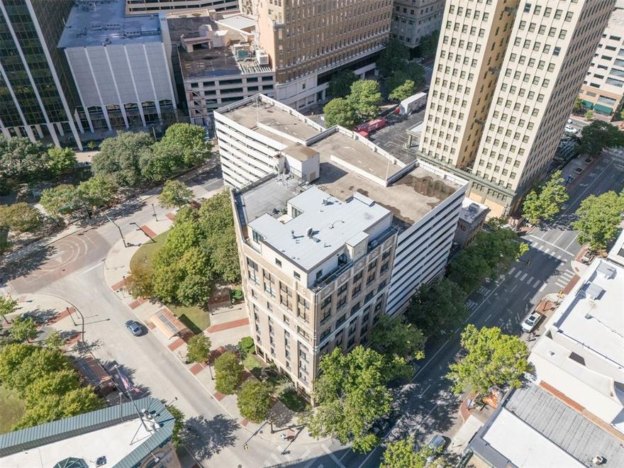 Cozy & comfortable 2nd floor condo overlooking historic Hyde Jennings Park & the iconic Fort Worth Flatiron Building. Located in the heart of downtown, surrounded by coffee spots, restaurants, & nightlife. New energy efficient Pella windows, and custom plantation shutters frame your sunny southern view. Freshly updated with bamboo floors, marble & granite finishes, designer plumbing fixtures and lighting. The open living area is enhanced by handsome exposed brickwork. Updated appliances include stacked laundry center, stainless steel fridge, microwave, & dishwasher. 2 deeded parking spaces in the attached garage are on the same level, just steps away. Condo includes a secure storage unit in the basement. 
Free Blue Line downtown shuttle stops outside the front door every 7 minutes, for quick access to T&P Station where commuter trains connect to downtown Dallas, Historic Fort Worth Stockyards, Grapevine Main Street, and DFW Airport Terminal B. 
The 9-story Houston Place Lofts was built in 1906 as The Western National Bank. In 2005 the building was converted into a 30 unit condo community. Rare opportunity to own a beautifully updated condo in this historically designated building.