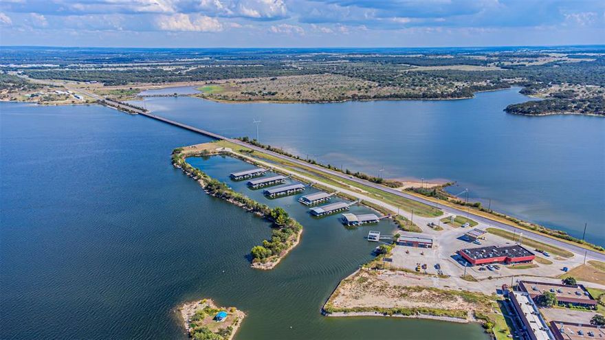 Discover affordable lake area living - your peaceful getaway in the heart of Runaway Bay.  Welcome to the lakeside community of Runaway Bay, a friendly golf-cart community along the shores of Lake Bridgeport - offering year round boating, fishing, and many other recreational and social activities and NO HOA.  This single-story home features an open and inviting layout, a wood-burning fireplace, and a split-bedroom design on over a third of an acre fenced lot. The kitchen is beautifully updated with quartz countertops, a farmhouse sink, and appliances. Relax in your private en-suite with double vanities, separate walk-in closets, a jacuzzi tub and shower. Enjoy quiet mornings and peaceful evenings outside on your private covered patio adjacent to a greenbelt. A three-car garage provides ample storage for lake toys, a golf cart, or a workshop space. Timeless craftsmanship and solid construction distinguish this home from newer builds. Escape from the congestion of the city and experience peaceful, easy living - where every day feels like a getaway, approximately 65 miles northwest of Fort Worth, TX.