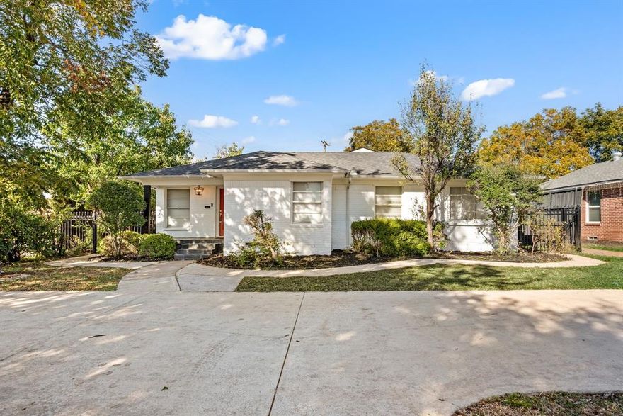 Welcome to this beautifully updated Dallas gem, where classic character and modern sophistication blend seamlessly. From the moment you arrive, the crisp white brick exterior and vibrant red front door create a warm and welcoming first impression, setting the tone for the charm within. Step inside to discover a light-filled living area adorned with soft neutral tones, crown molding, and rich hardwood floors.  The updated kitchen is a true centerpiece — showcasing butcher block countertops, stainless steel appliances, open shelving, and custom cabinetry with vintage-style hardware. A cozy breakfast nook with built-ins and designer wallpaper provides a stylish spot to enjoy your morning coffee. The home’s elegant hallway features timeless lighting and glass sliding doors that lead to a covered patio overlooking the private backyard. The spacious primary suite offers a calming escape with large windows, warm wood tones, and sophisticated lighting. The ensuite bath exudes spa-like luxury with a marble-tiled shower, a clawfoot soaking tub, and gold-accented fixtures that pair beautifully with dual vanities and crystal chandeliers. Completing the primary wing is a stunning custom closet, featuring abundant built-ins, a center island with mirrored top, and a statement chandelier. Additional highlights include a large utility room with extra storage, multiple flexible living spaces, and a fenced backyard perfect for entertaining or relaxing outdoors. Perfectly located in north Dallas, this home offers a rare combination of character, craftsmanship, and modern convenience. Schedule your showing today!