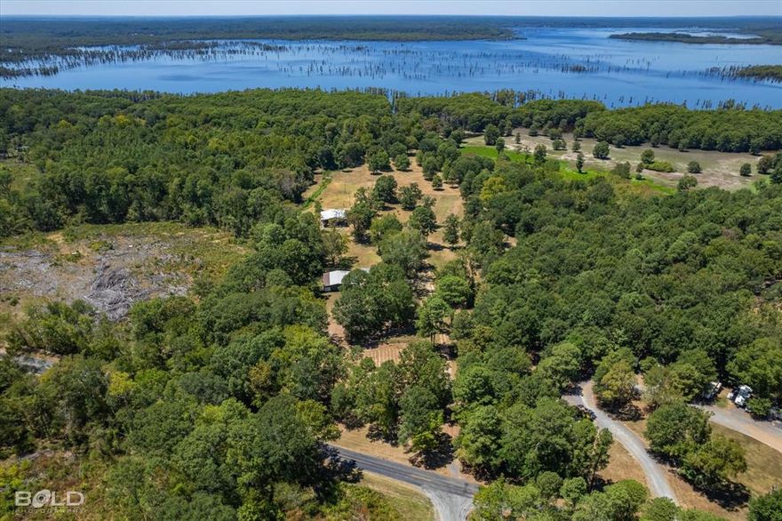 PRICE IMPROVEMENT! Welcome to Your Ultimate Sportsman's Paradise on Lake Bistineau! Discover the epitome of outdoor enthusiasts' dreams with this exceptional property boasting over 2000ft of breathtaking water frontage. Nestled on a sprawling 30.42 acres of unspoiled natural beauty, this fully furnished 3b 2ba home with bonus room beckons you with 2 levels of front and back porches spanning the length of the house capturing ideal vantage points to soak in sunrises and sunsets. Constructed to withstand gale force winds of 125mph! Hunters, fantastic deer, duck and hog hunting awaits! And when you're ready to cast a line, fish from your own shoreline! Whether you're looking for a home, hunting and fishing camp, or horse property, there's a large workshop equipped with electricity, 4 rooms, full bath, garage doors, 3 deer feeders, deer stands, hog pen, 1 acre fenced in garden area irrigated by the creek, john boat, tractor and more ensuring you can dive into your outdoor adventures day 1!