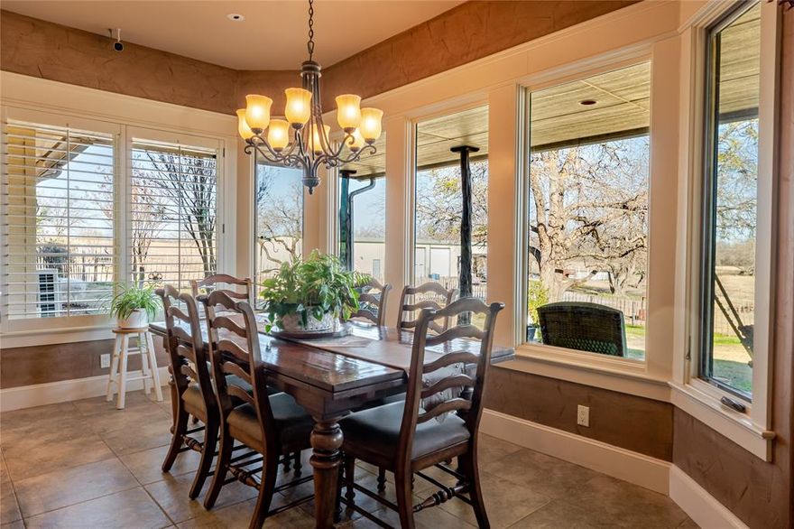 Beautiful 19+ acre AG-exempt estate in Denton County offering a rare combination of luxury living, privacy, and a fully functional ranch setup. Ideal for buyers seeking a working cattle or livestock property, multi-use estate, or peaceful country retreat with modern amenities. The custom-built rock home features 3 bedrooms and 2 bathrooms with vaulted ceilings, exposed wood beams, hand-scraped hardwood floors, bay windows, and a striking stone fireplace. The open-concept kitchen is designed for everyday living and entertaining, offering granite countertops, custom cabinetry, a propane range, and an oversized walk-in pantry. Natural light fills the home and frames scenic views of mature trees, native grasses, and wide-open pasture. The primary suite is a true retreat with a spa-like bath, including a large soaking tub, walk-in shower, dual vanities, and an impressive boutique-style closet with extensive built-ins. Two additional bedrooms share a Jack-and-Jill bath and provide generous closet space and classic shutters. Outdoor living is highlighted by expansive stamped-concrete porches, custom lighting, and peaceful views of the land. The property includes a stocked tank with powered dock, ideal for relaxation or recreation. A standout feature is the massive 6,000-square-foot workshop offering exceptional versatility with multiple roll-up doors, including a loading dock, 3-phase electricity, 50-amp service, dedicated HVAC, and air compressor. The attached apartment conveys fully furnished, making it ideal for guests, rental income, multi-generational living, or a ranch hand residence. Additional improvements include a deep well with 2,500-gallon holding tank, 7-zone sprinkler system, spray-foam insulation, tankless hot water heater, updated HVAC units, propane stove and fireplace, security system with cameras, and a whole-property generator. Pens, corrals, fencing, and working areas support cattle operations and preserve the AG exemption.